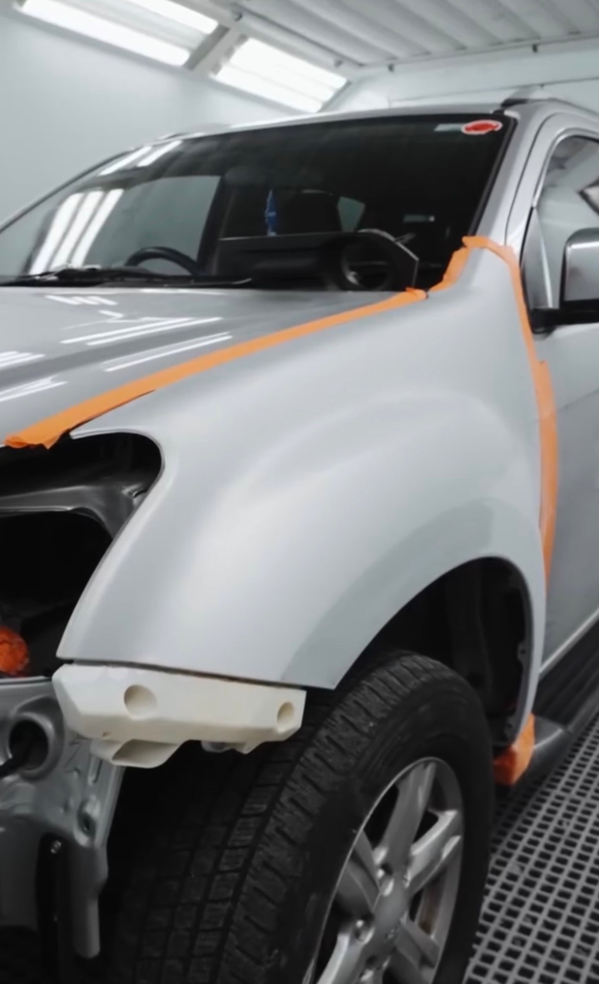 Silver ute front guard masked up for paint repair