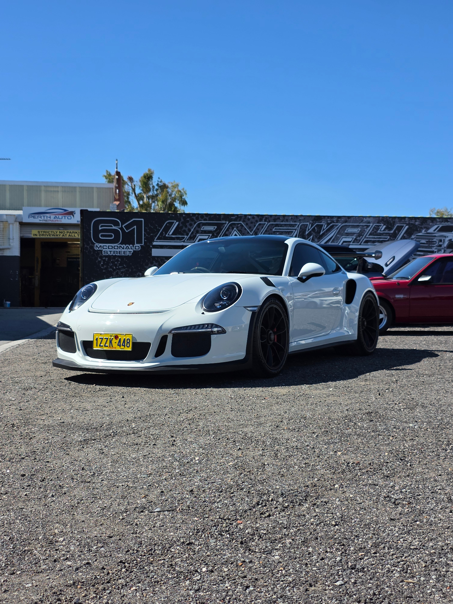 White Porsche GT3 RS front three-quarter at the premises