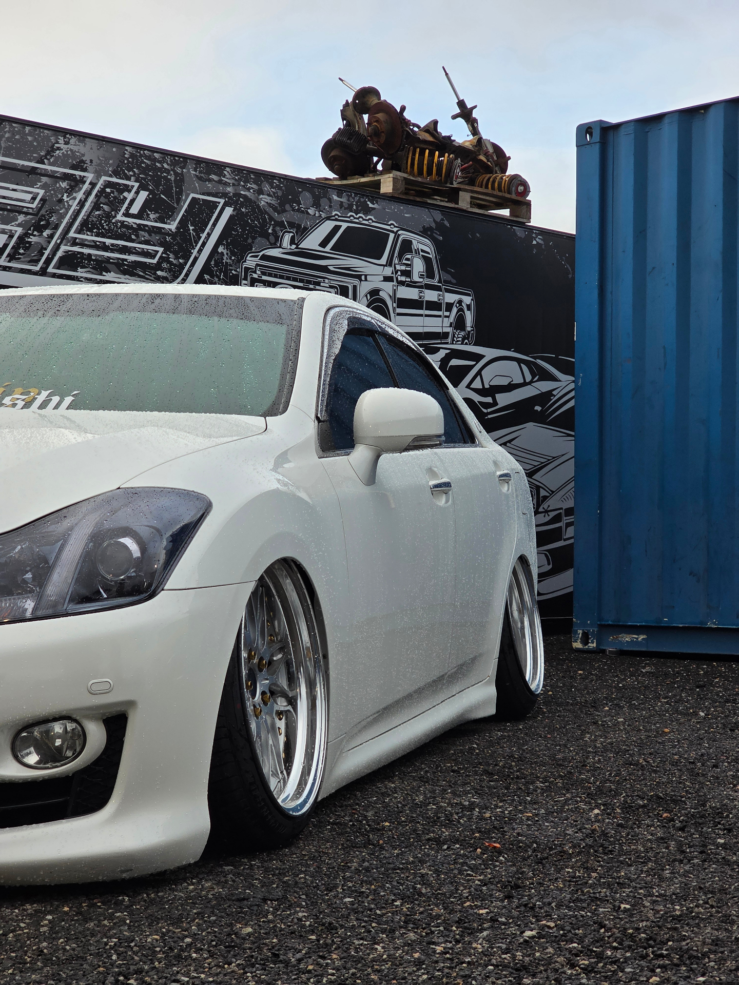 White VIP-style JDM sedan at the Laneway wall
