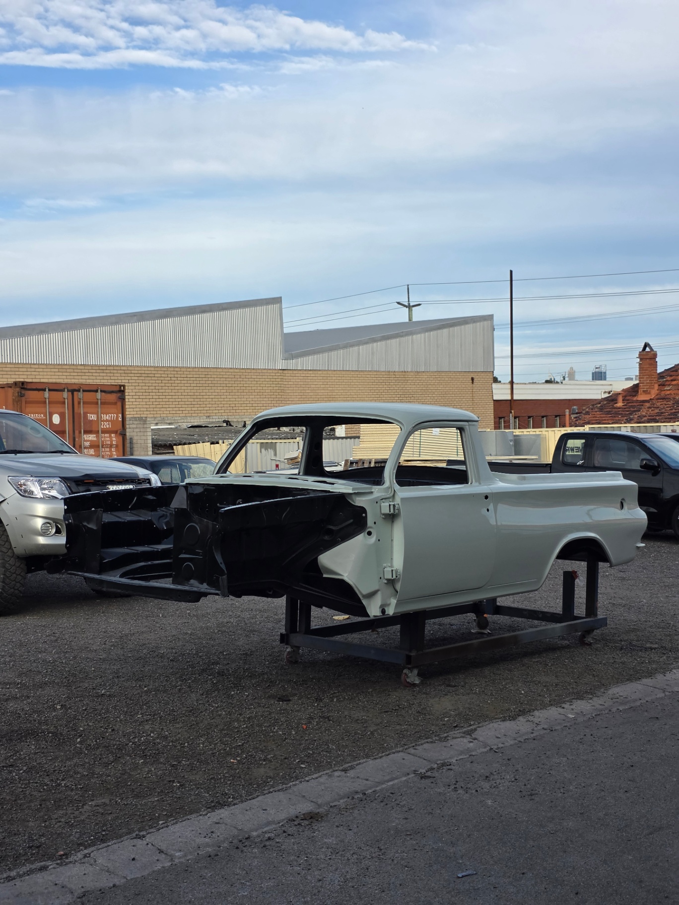 Grey-primer ute body shell on the rotisserie