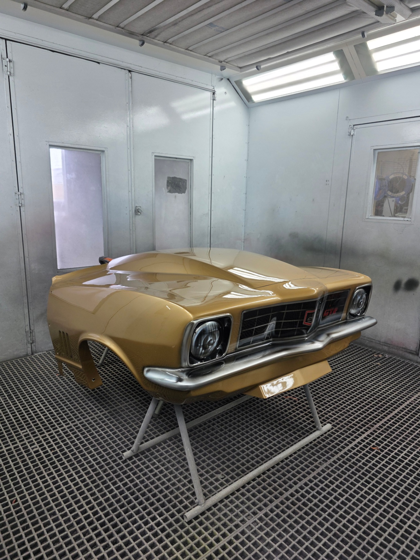 Gold Holden coupe freshly painted in the spray booth